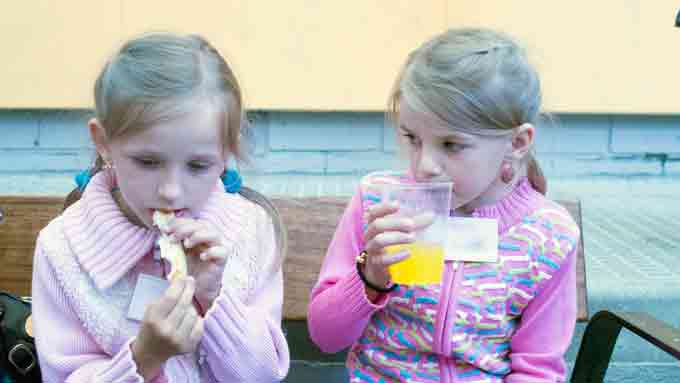 Dos de las niñas comiendo algo después del largo viaje